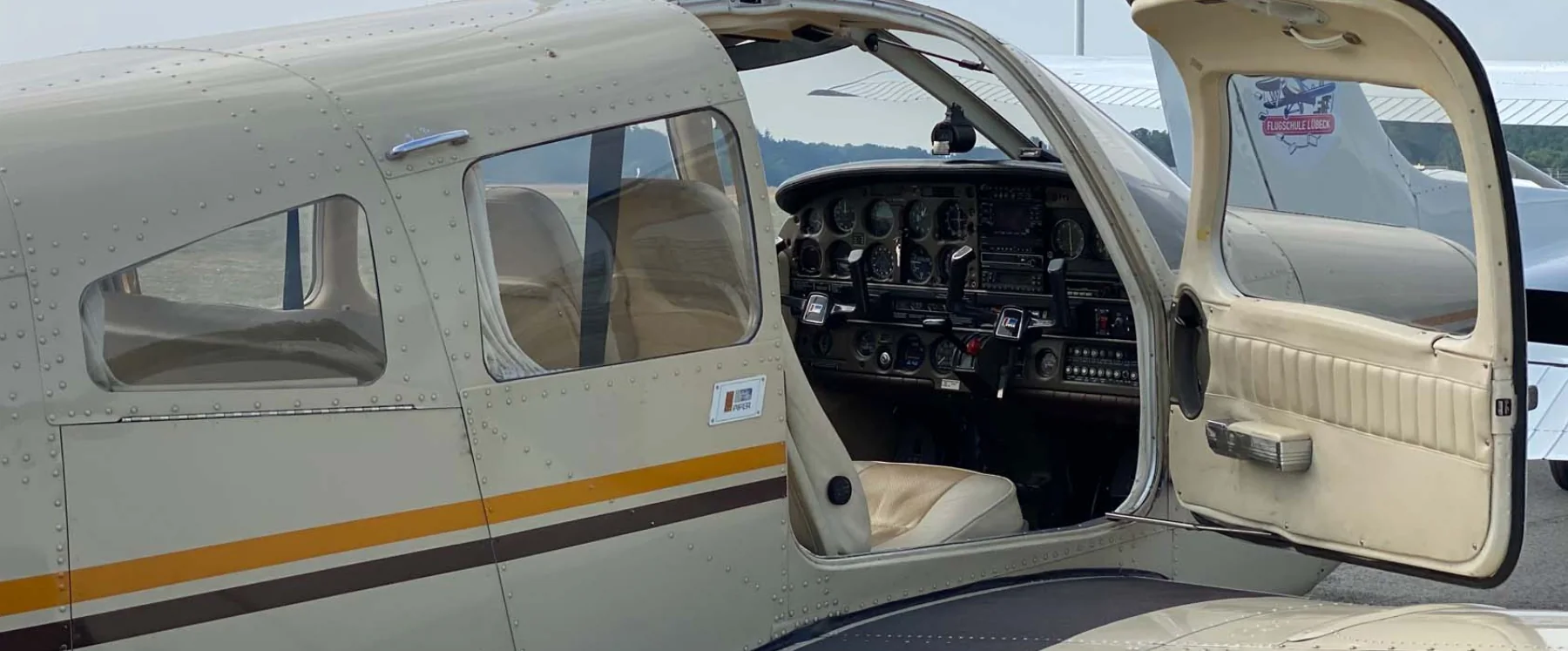 Reiseflugzeug mit geöffneter Tür und Blick ins Cockpit
